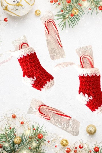 two red and white crocheted Christmas stockings with mini candy canes